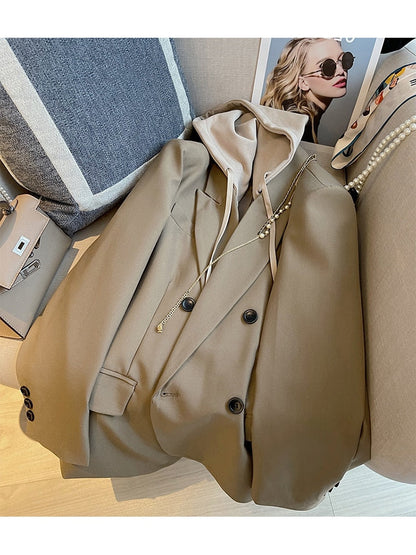 Beiger Blazer mit Kapuze, Damenmode, eleganter Stil, Herbstkollektion, auf Sofa drapiert.