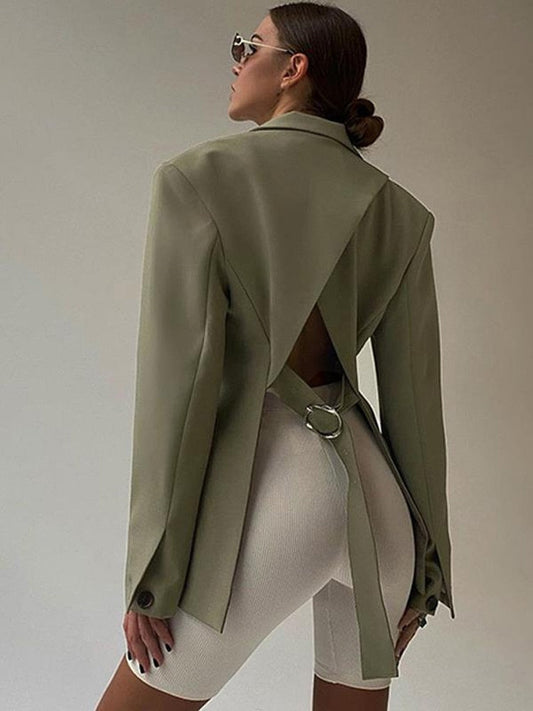 Frau in olivgrünem Blazer mit offenem Rücken, weiße Radlerhose, modisch, elegant.