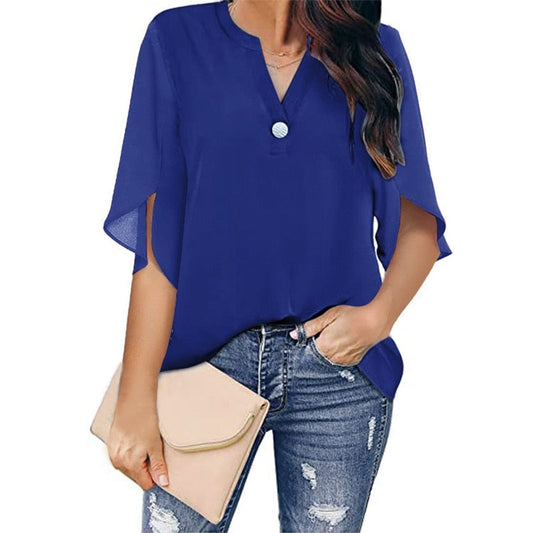 Frau in blauer Bluse mit V-Ausschnitt, zerrissene Jeans, beige Clutch, modisch, lässig.