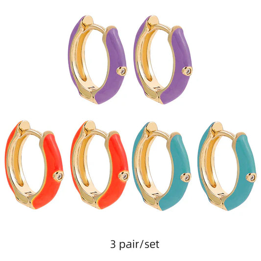 Drei Paar bunte Creolen-Ohrringe, goldfarben, lila, orange, türkis, modisches Schmuckset.