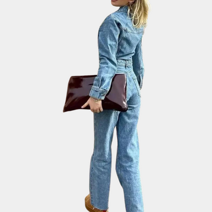 Frau in blauer Jeansjacke und Jeans, hält braune Clutch, Mode, Freizeitkleidung.
