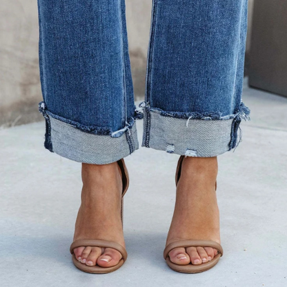 Damenjeans mit ausgefranstem Saum, blaue Denim, modische Sandalen, lässiger Stil.