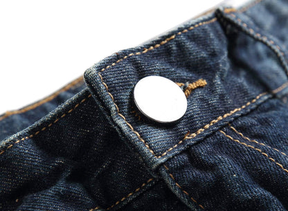 Nahaufnahme einer blauen Jeans mit silbernem Knopf, Denim-Stoff, robuste Nähte.