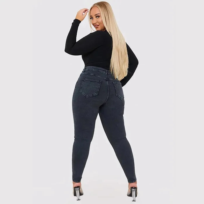 Frau in schwarzem Langarmshirt und dunkelblauer Jeans, Rückansicht, modisch, lässig, elegant.