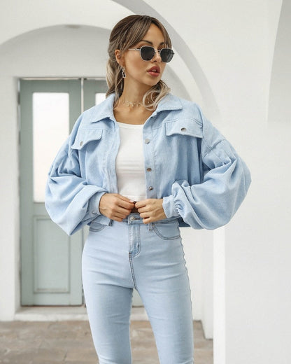 Frau in hellblauer Cordjacke und Jeans, Sonnenbrille, modisch, lässig, urbaner Stil.