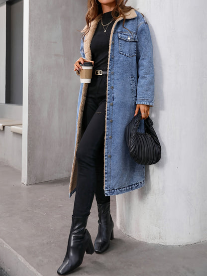 Frau in blauem Jeansmantel mit schwarzer Tasche und Stiefeln, hält Kaffeebecher.