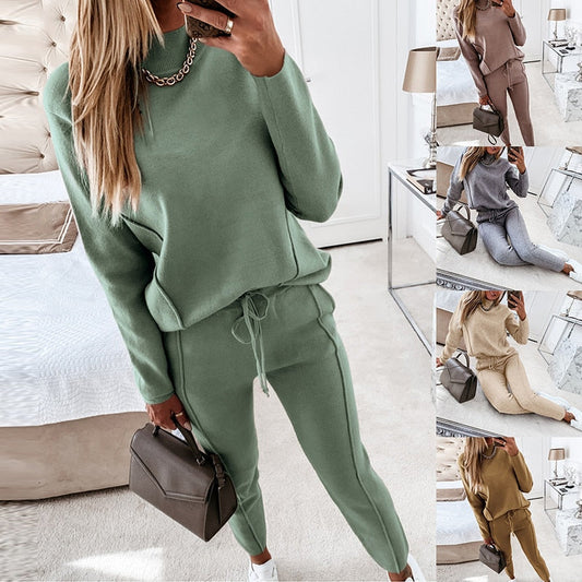 Frau in grünem Jogginganzug, hält braune Handtasche, Schlafzimmer, Mode, Freizeitkleidung.