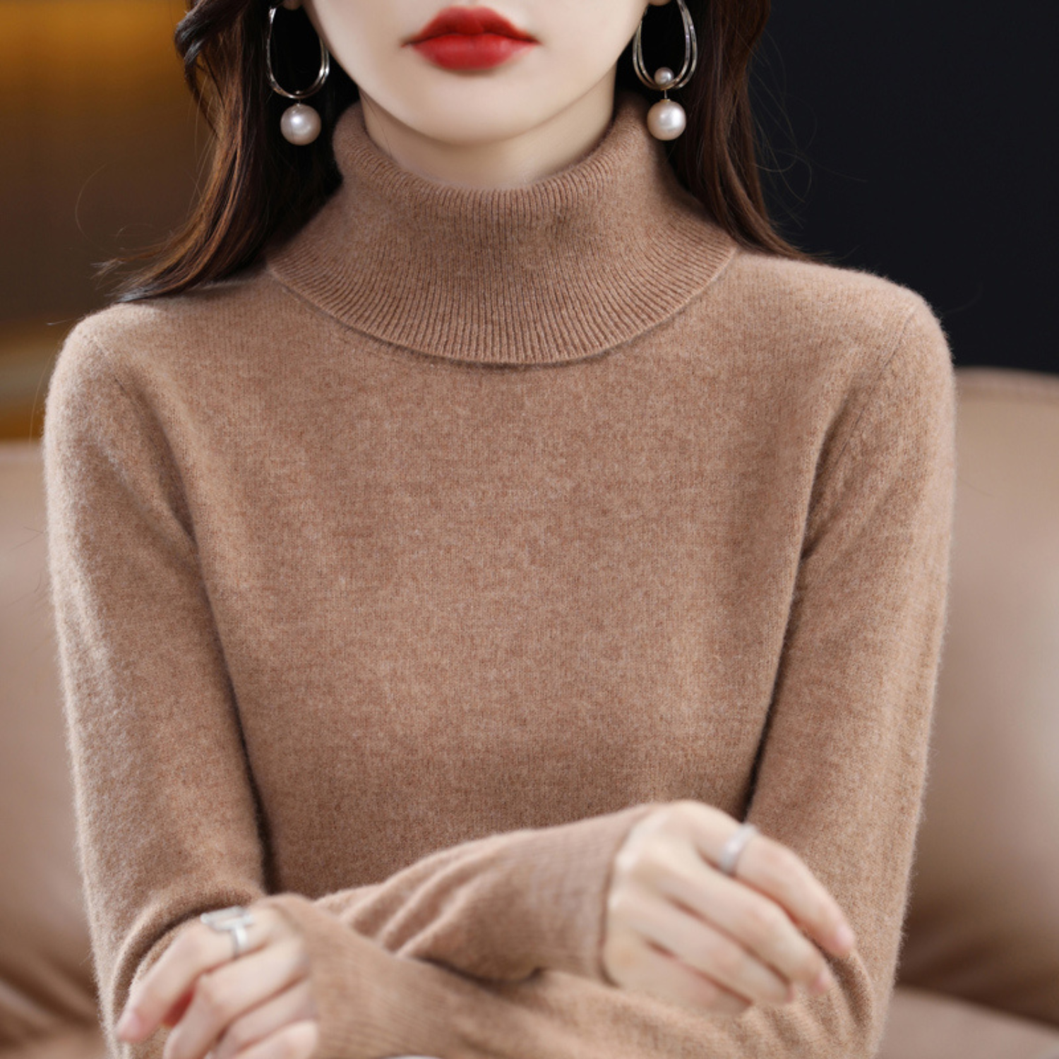 Frau in braunem Rollkragenpullover aus Kaschmir, elegante Ohrringe, modisches Herbstoutfit.