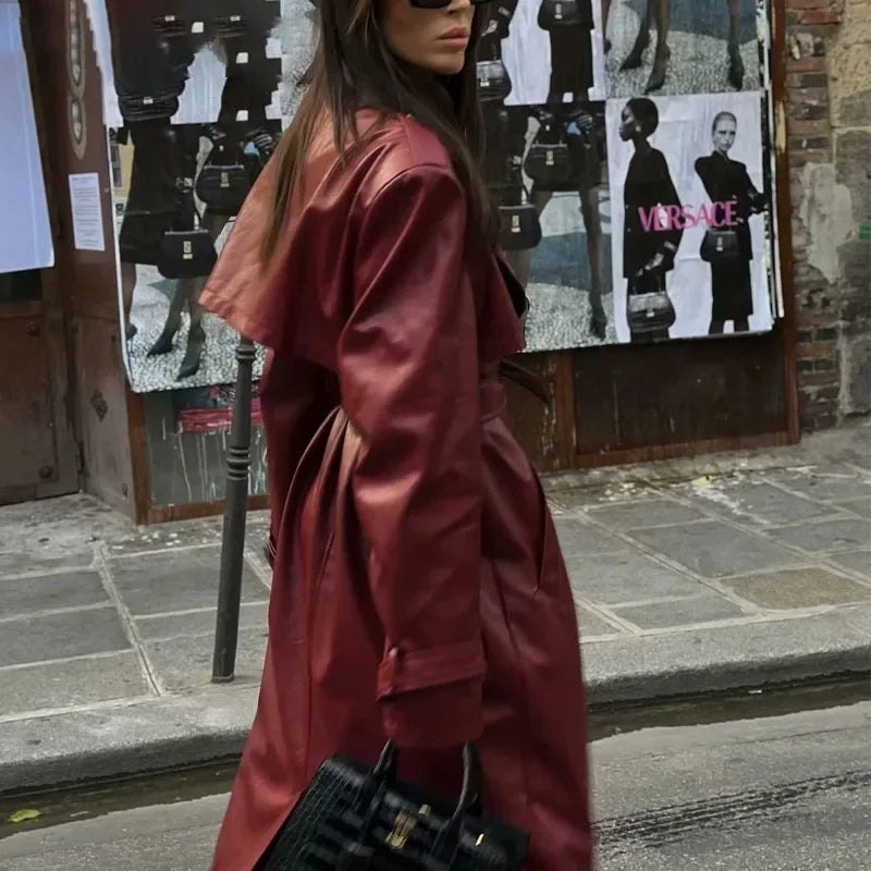 Frau in rotem Ledermantel, schwarze Sonnenbrille, schwarze Handtasche, Stadtstraße, Mode.