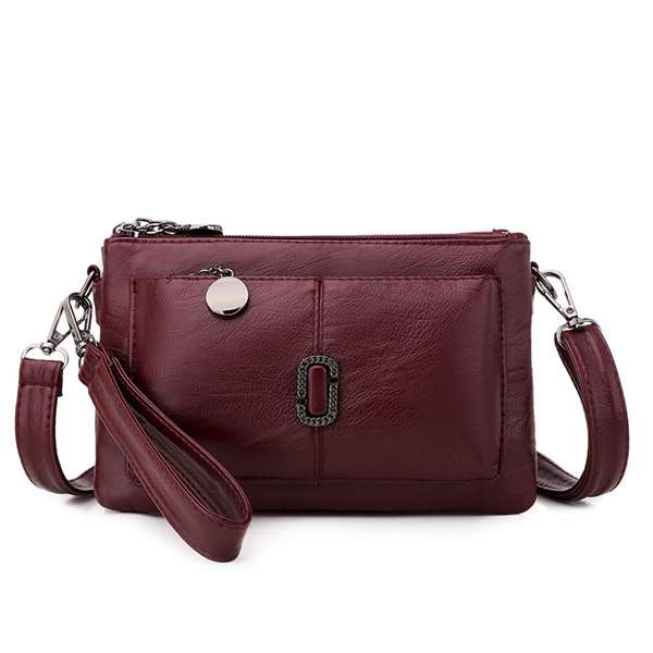 Bordeauxrote Lederhandtasche mit abnehmbarem Riemen, Reißverschluss und Metallakzenten.
