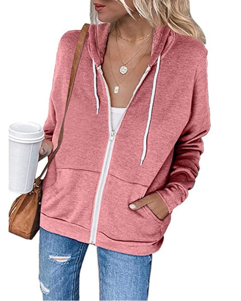 Frau in rosa Kapuzenjacke mit Kaffeebecher und brauner Tasche, lässige Mode.