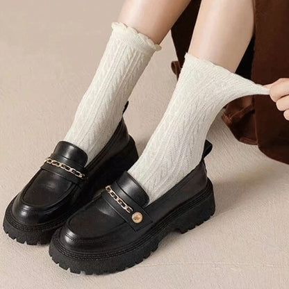 Schwarze Loafer mit Kettenverzierung und weißen Socken, Damenmode, trendige Schuhe.