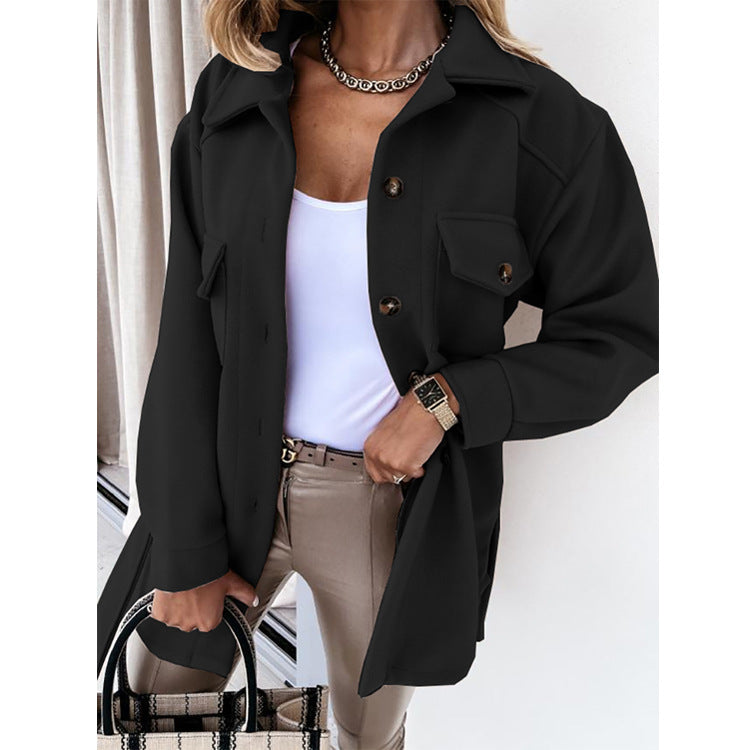 Frau in schwarzer Jacke, weißem Top, beiger Hose, hält karierte Handtasche, modisch, elegant.