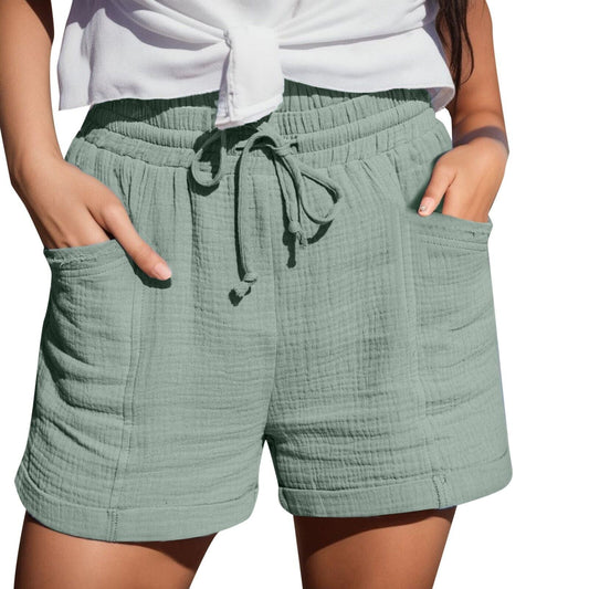 Frau in grünen Baumwollshorts mit Taschen und Kordelzug, Sommermode, Freizeitkleidung.