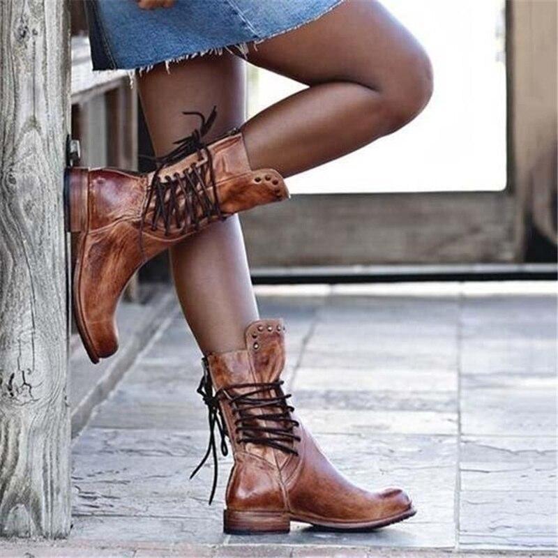 Frau trägt braune Lederstiefel mit Schnürung, lässiger Stil, modische Damenstiefel.
