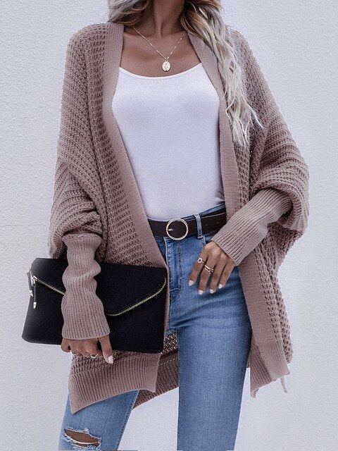 Damen Strickjacke beige, Herbstmode, lässig, lang, mit schwarzer Clutch, modisch, elegant.
