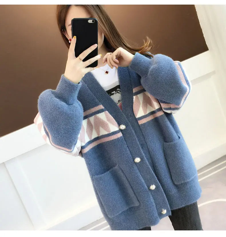 Frau trägt blauen Strickcardigan mit geometrischem Muster und Knöpfen, modisch, warm.