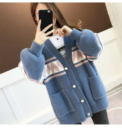 Frau trägt blauen Strickcardigan mit geometrischem Muster und Knöpfen, modisch, warm.