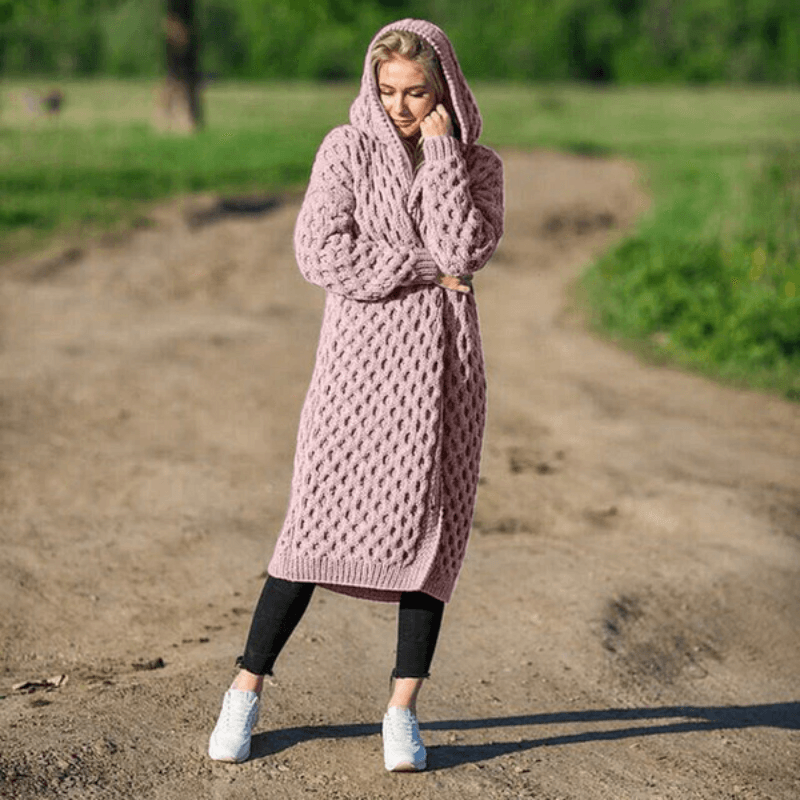 Frau in rosa Strickmantel mit Kapuze, lässig, übergroß, Herbstmode, draußen.