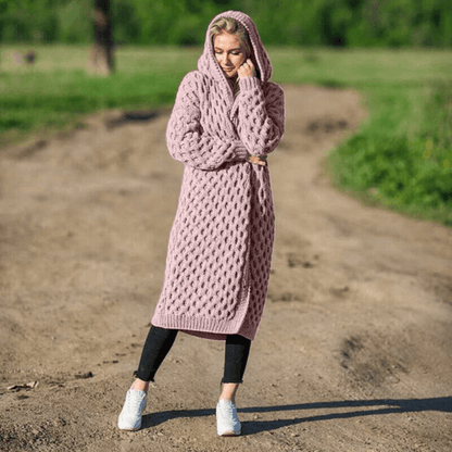 Frau in rosa Strickmantel mit Kapuze, lässig, übergroß, Herbstmode, draußen.