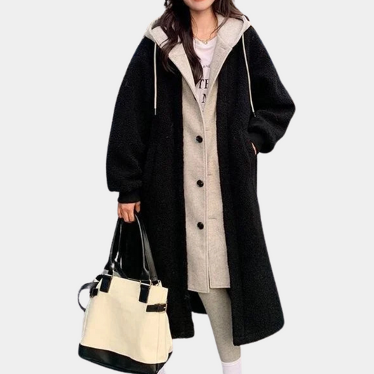 Frau in schwarzem Wollmantel mit Kapuze, hält weiße Tasche, modisch, Herbstkleidung.
