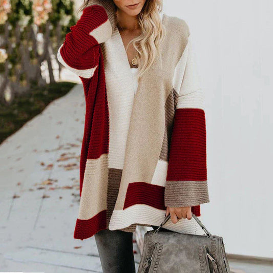 Frau in stilvollem, mehrfarbigem Damenpullover mit Muster, hält graue Handtasche.