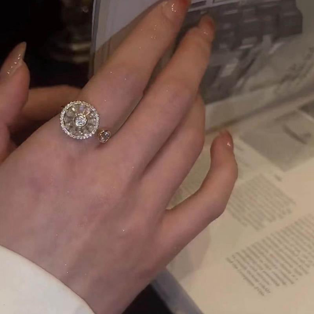 Hand mit funkelndem Diamantring, rund, Silber, beim Blättern in einem Buch.