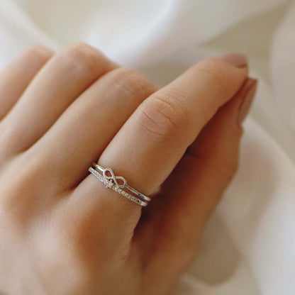 Silberner Unendlichkeitsring mit Diamanten auf Hand, eleganter Schmuck, Verlobungsring.