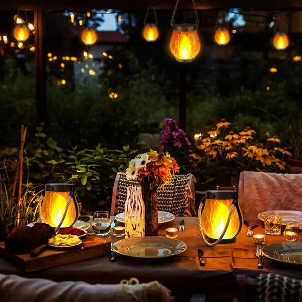 Gedeckter Abendtisch im Garten mit zwei Laternen auf dem Tisch und weiteren darüber hängend 7