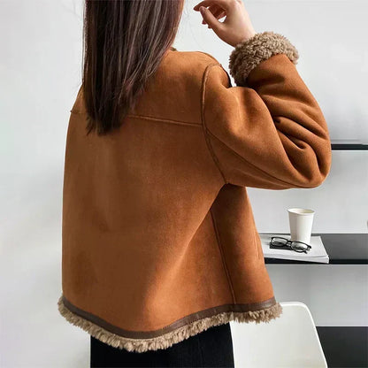 Rückansicht der braunen Jacke mit Lammfellsaum am unteren Rand und am Ärmel, Model hebt die Hand 3