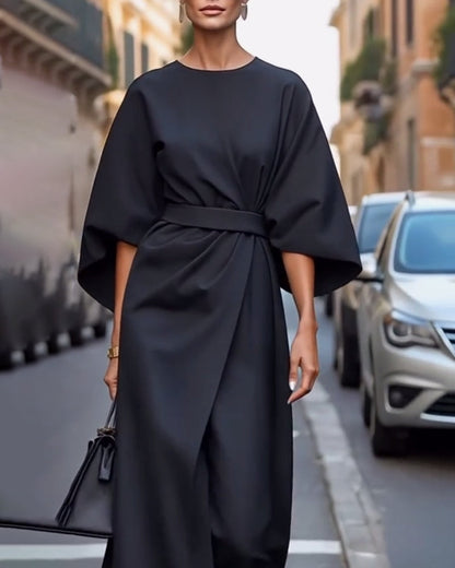 Schwarzes Kleid mit weiten Ärmeln und Gürtel an der Taille, getragen mit Ohrringen und schwarzer Tasche, Ansicht von Kopf bis Knie. 4
