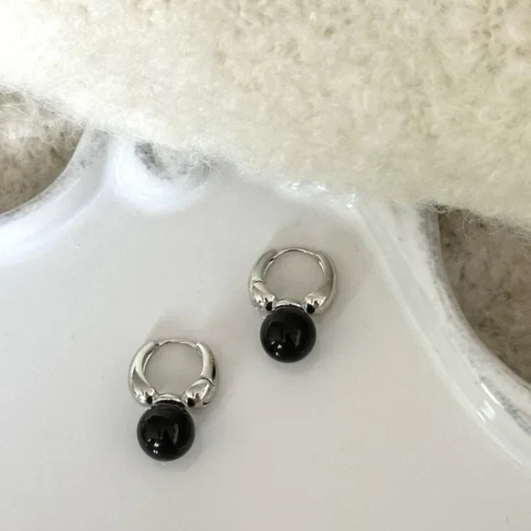 Silberne Ohrringe mit schwarzen Perlen, eleganter Schmuck, modisches Accessoire, Damenmode.