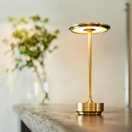 Goldene LED-Tischlampe aus Metall auf Holztisch, modernes Design, energiesparend.