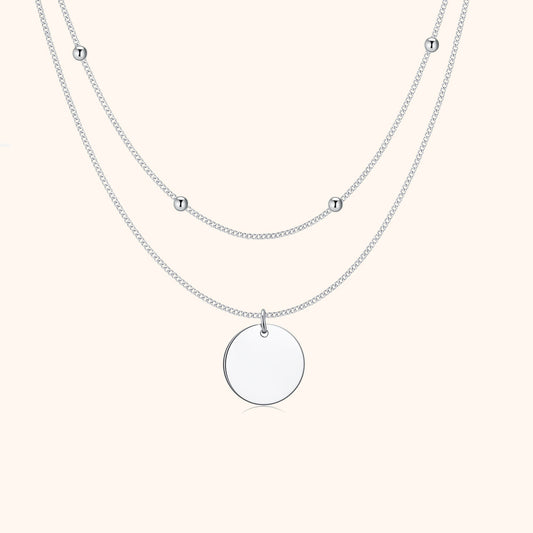 Silberne Halskette mit rundem Anhänger und kleinen Kugeln, elegantes Schmuckdesign.