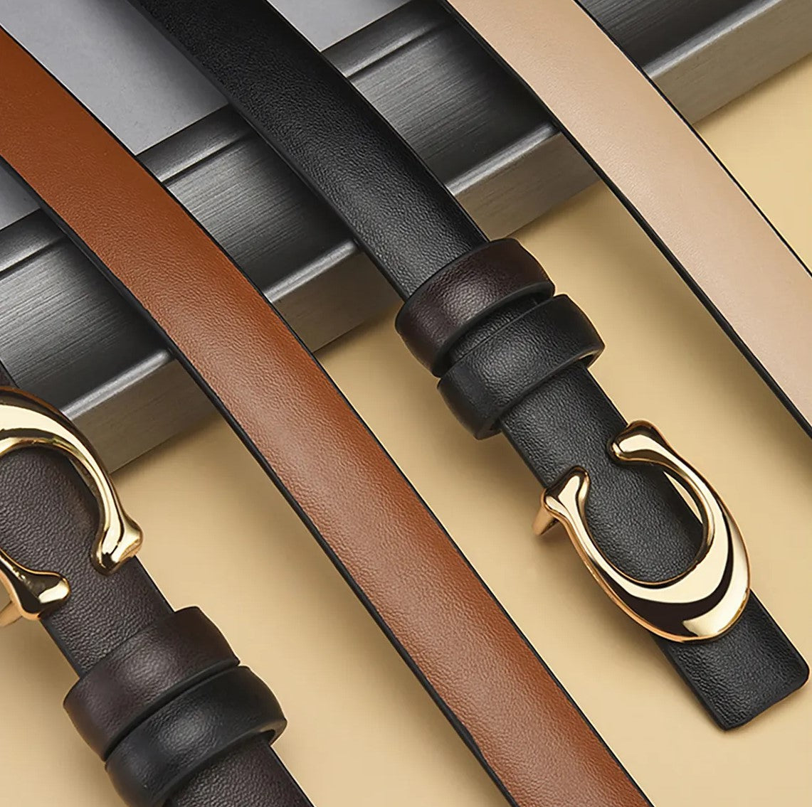 Dünner Ledergürtel mit doppelseitiger C-Schnalle in Schwarz und Braun, modisches Accessoire.