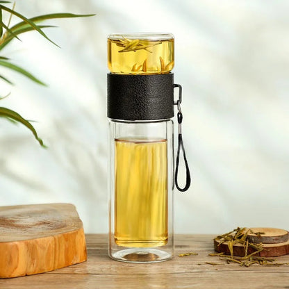 Doppelwandige Glas-Teeflasche mit schwarzem Ledergriff, ideal für unterwegs.