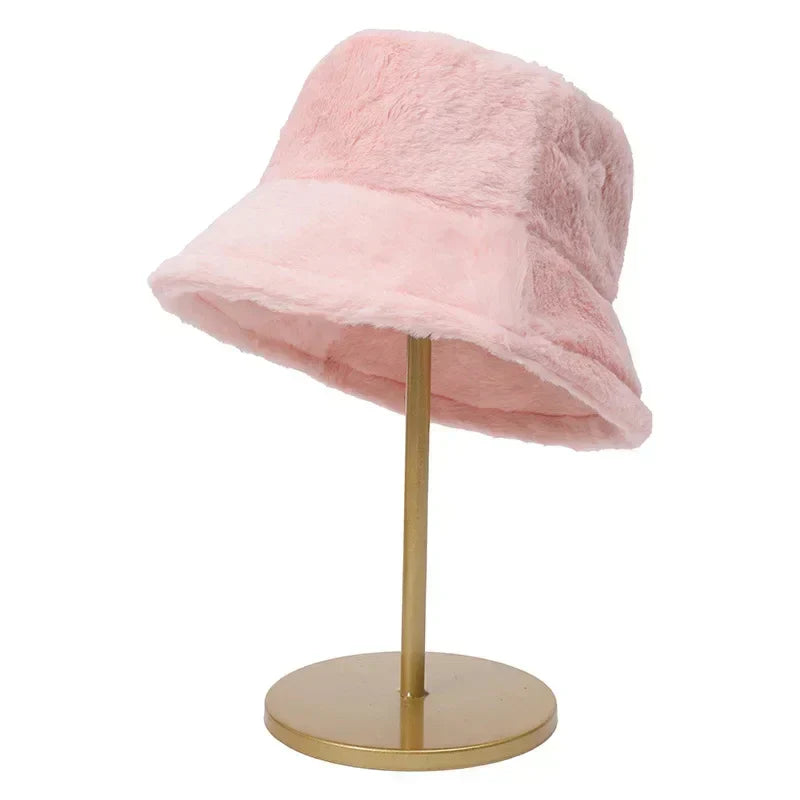 Rosa Plüsch-Bucket-Hut auf goldenem Ständer, modisches Accessoire, Wintermode.