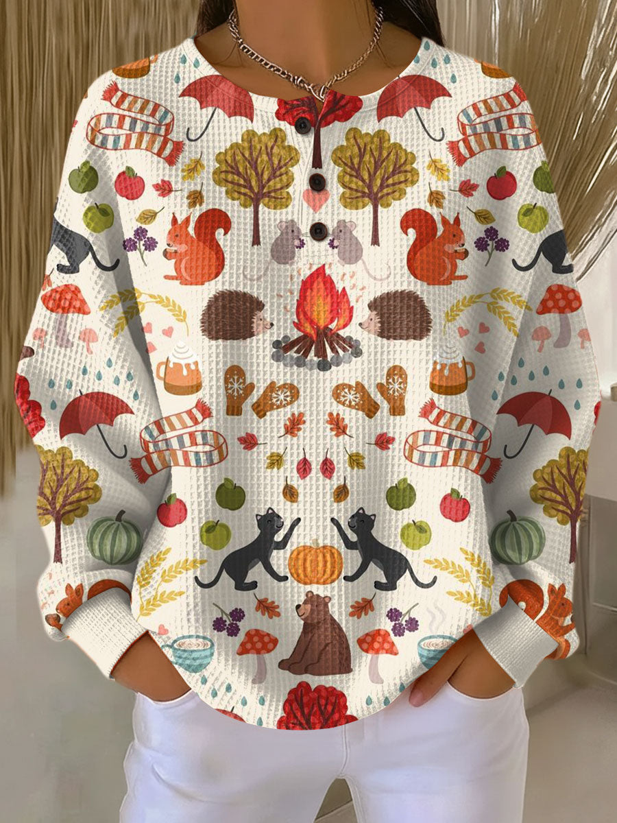 Cremefarbener Pullover mit Knopfleiste und herbstlichem Print aus Eichhörnchen, Igeln, Katzen, Lagerfeuer, Pilzen und Kürbissen. 19