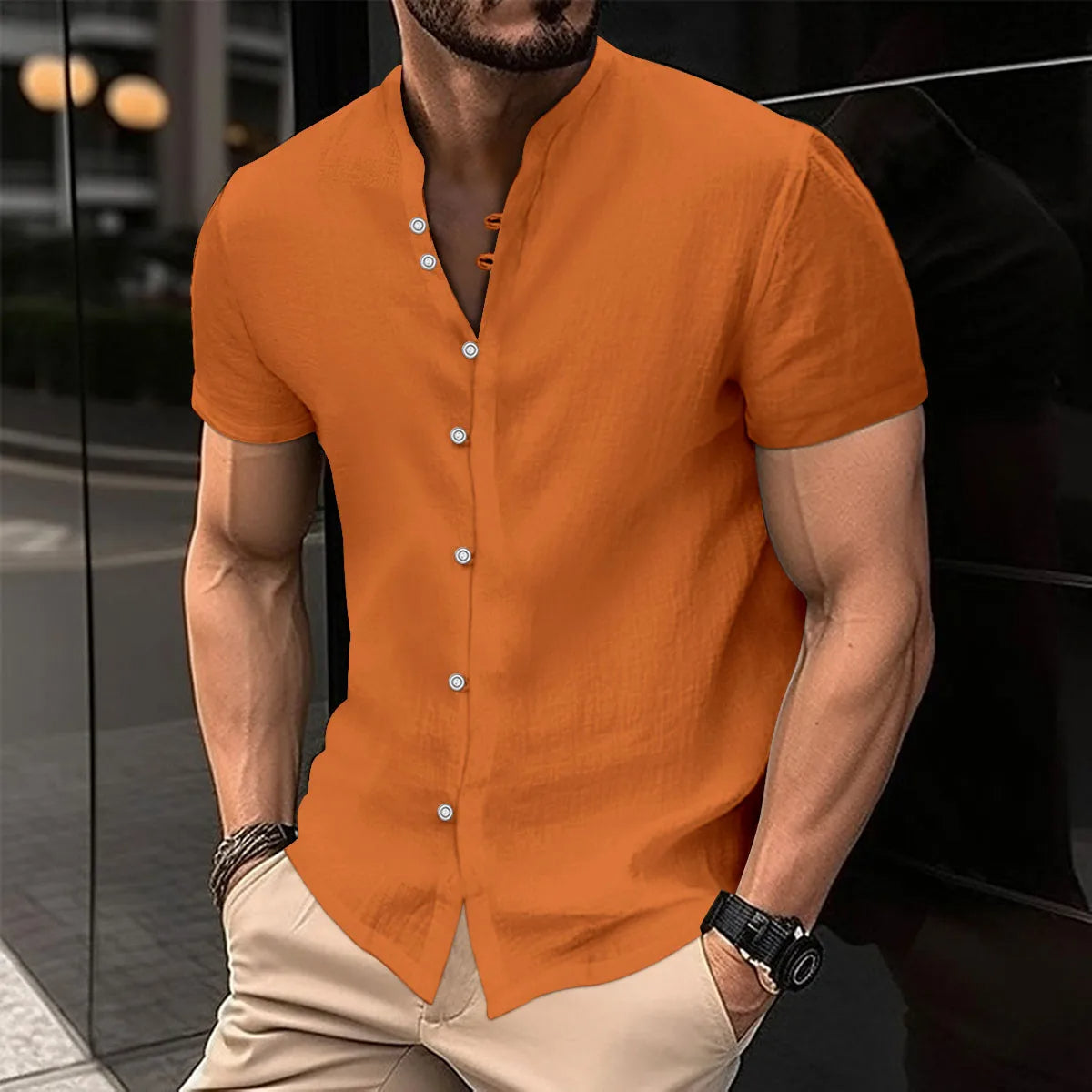Mann in orangefarbenem Leinenhemd, kurzärmelig, mit Knopfleiste, lässiger Sommerstil.