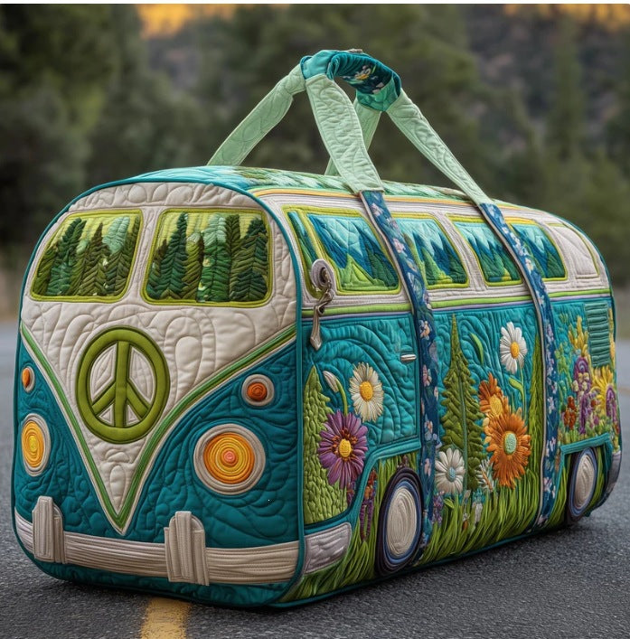Gesteppte Reisetasche in Bulli-Form mit Friedenszeichen, Blumenwiese und Tannenwald-Fenstern, schräg von vorn auf einer 1