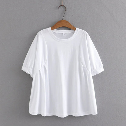 Weißes Damen-T-Shirt aus Baumwolle, kurzärmelig, auf Holzkleiderbügel vor grauer Wand.