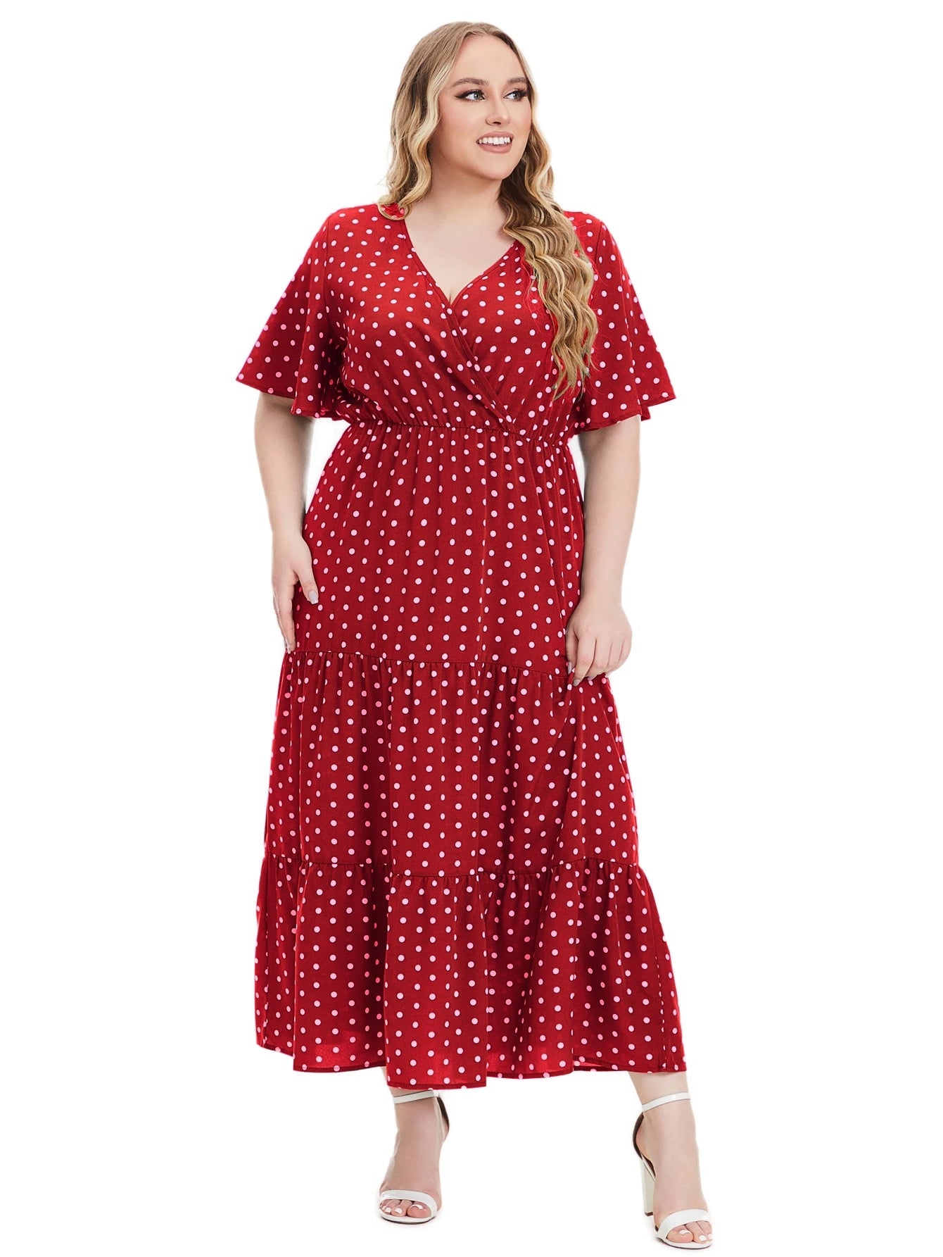 Frau im roten gepunkteten Maxikleid, V-Ausschnitt, kurze Ärmel, Plus-Size-Mode.