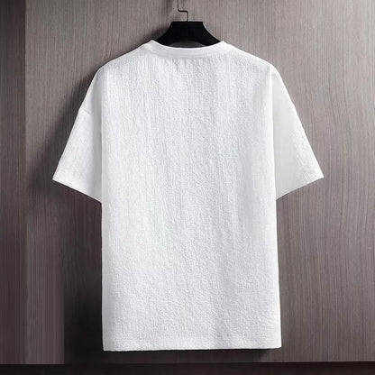 Weißes T-Shirt aus Baumwolle, kurzärmelig, auf Holzbügel, minimalistisch, unisex.