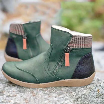 Grüne Stiefeletten mit seitlichem Reißverschluss, kariertem Schaftrand und dunkler Fersenkappe, auf einem Stein im Freien fotografiert. 1