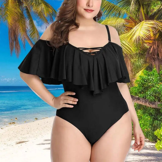 Frau im schwarzen Badeanzug am tropischen Strand mit Palmen und blauem Meer.