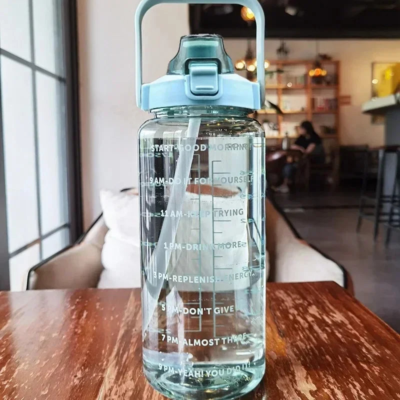 Transparente Wasserflasche mit Zeitmarkierungen, blauer Deckel, motivierende Trinkziele.