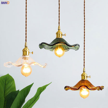 Drei Vintage-Pendelleuchten aus Glas in Grün, Bernstein und Klar mit Edison-Glühbirnen.