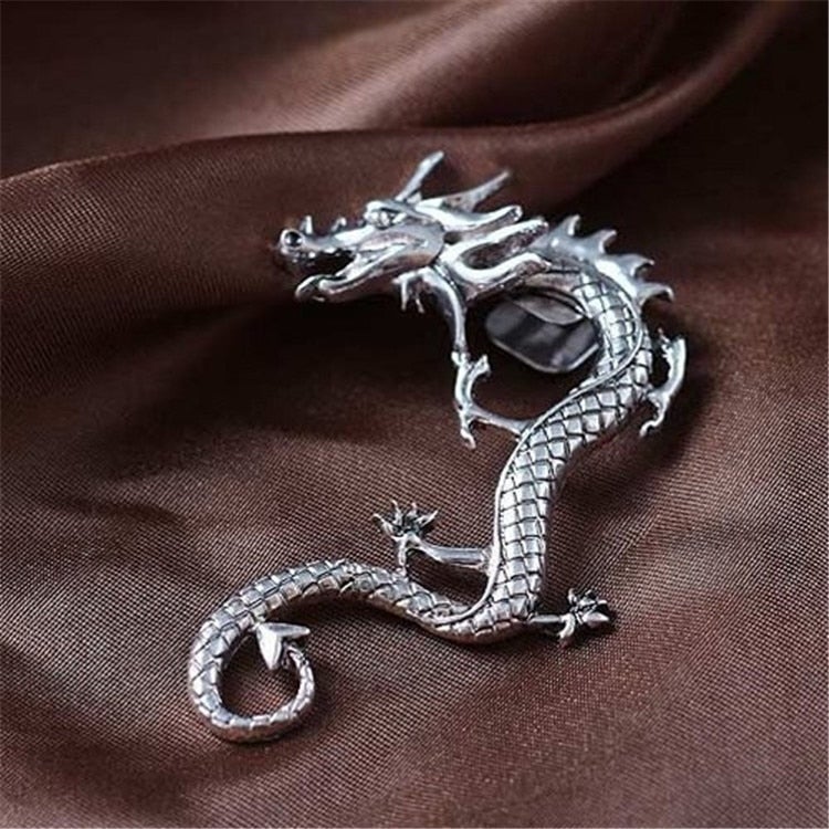 Silberner Drachenbrosche auf braunem Stoff, elegantes Schmuckstück, Geschenkidee.