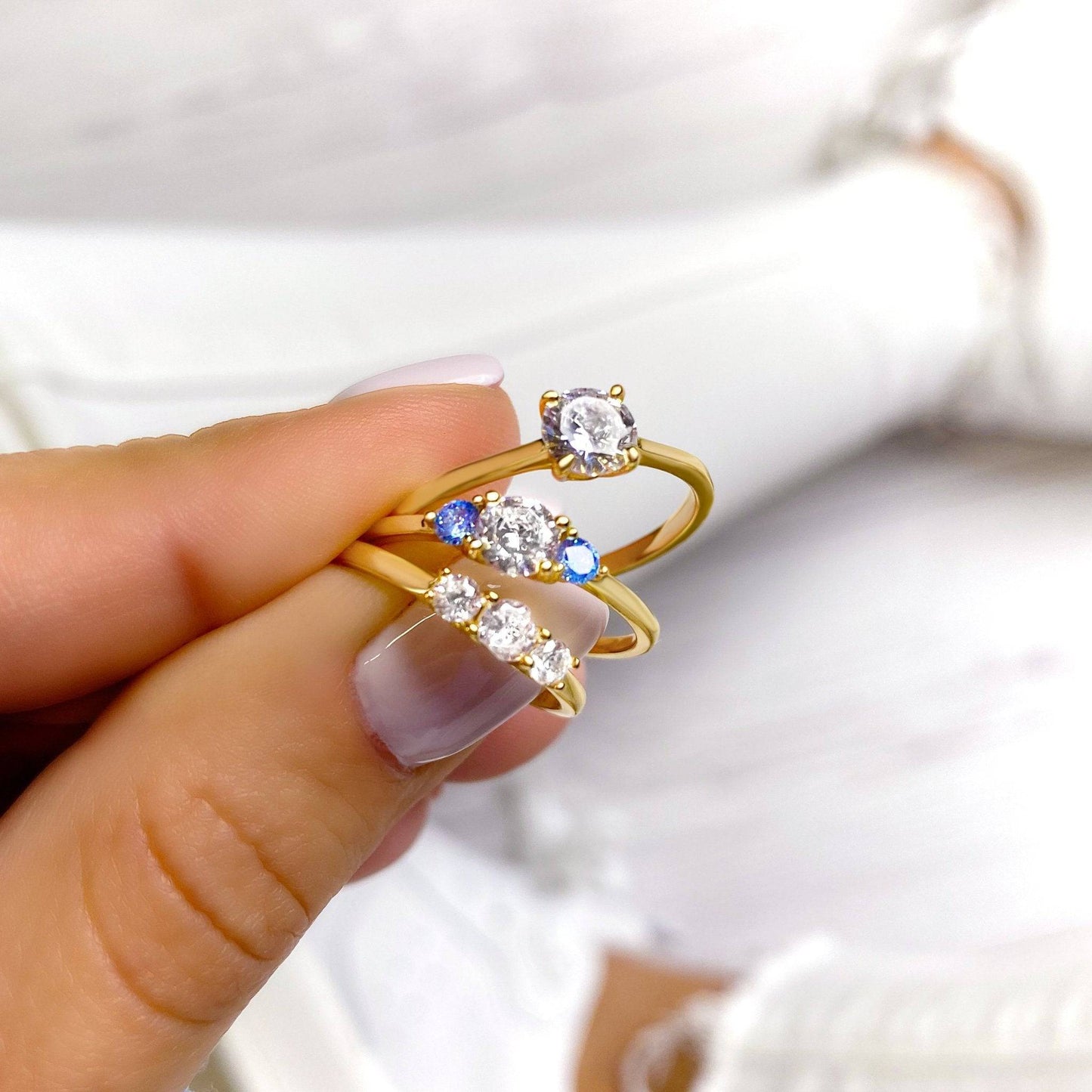 Goldene Ringe mit Diamanten und blauen Steinen, eleganter Schmuck, luxuriöses Design.