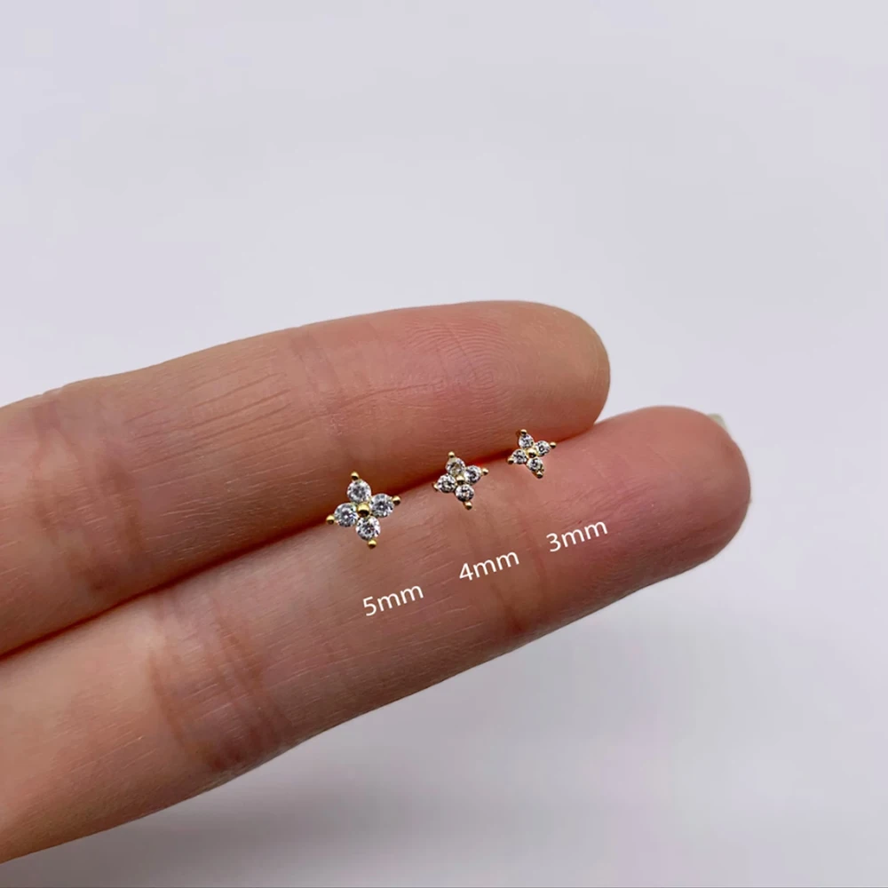 Drei goldene Ohrstecker mit Zirkonia, Größen 3mm, 4mm, 5mm, auf Finger präsentiert.